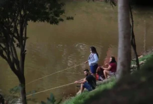 Pescador praticando pesca de barranco em represa de água doce
