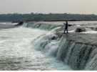 Pescador praticando pesca esportiva em rio de correnteza forte utilizando técnicas para capturar peixes com mais eficiência.
