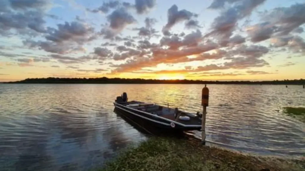 Lagoa Juparanã: a maior lagoa do ES para pescar e quais peixes encontrar. 9 Barco navegando na Lagoa Juparanã durante pescaria esportiva em águas calmas no Espírito Santo.