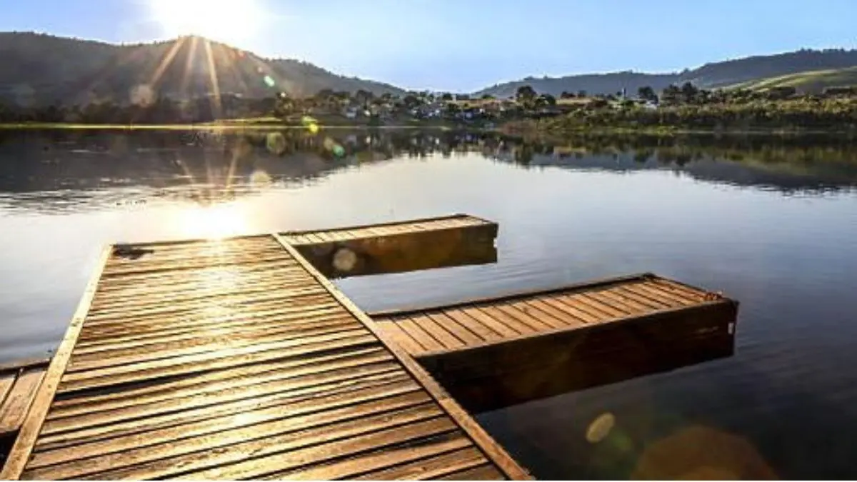 Os 8 Mandamentos do pesqueiro: regras de ouro para pescar melhor. 1 Paisagem de pesqueiro em ambiente natural destacando a pesca responsável e sustentável.