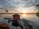 Pousada de pesca esportiva às margens de rio brasileiro com barcos e estrutura para pescadores.