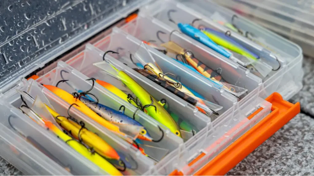 Caixa de pesca organizada com diferentes cores de iscas artificiais para variadas condições de pesca.