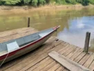 Rancho de pesca às margens de um rio com estrutura de hospedagem para pescadores.