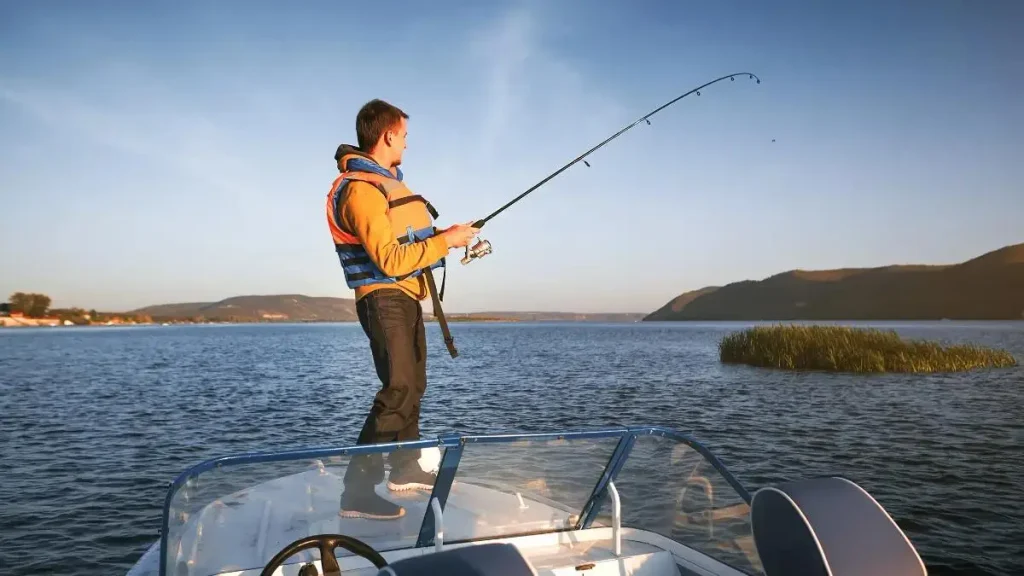 Pescador em barco usando vara adequada para pesca embarcada.